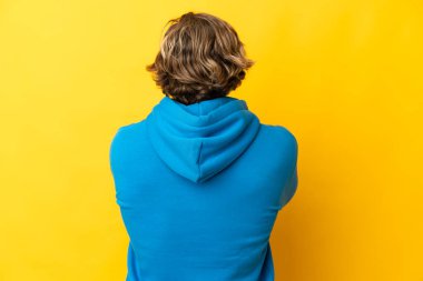 Sarışın yakışıklı adam sarı arka planda izole edilmiş.