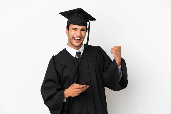 Fiatal Egyetemi Diplomás Elszigetelt Fehér Háttér Telefon Győzelmi Pozícióban — Stock Fotó
