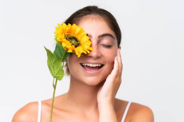 Young Pretty caucasian woman isolated on white background holding a sunflower while smiling. Close up portrait