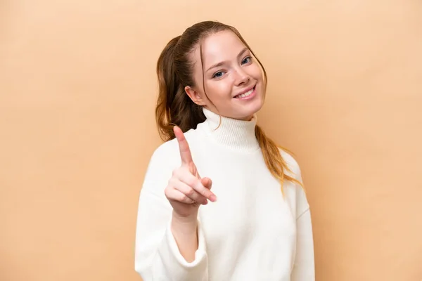 Mujer Joven Caucásica Aislada Sobre Fondo Beige Mostrando Levantando Dedo —  Fotos de Stock