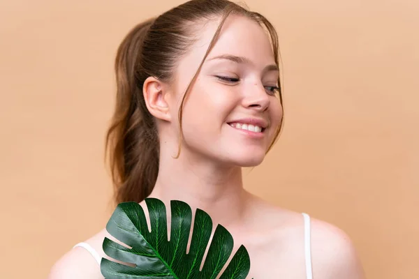Young Caucasian Girl Isolated Beige Background Holding Palm Leaf Close — Stock Photo, Image