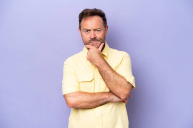 Orta yaşlı, beyaz bir adam. Mor arka planda izole edilmiş.