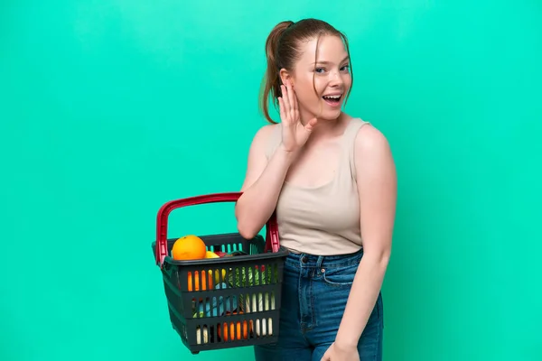 Young Woman Holding Shopping Basket Full Food Isolated Green Background — Φωτογραφία Αρχείου