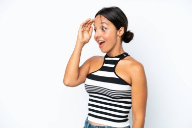 Young hispanic woman isolated on white background with surprise expression while looking side