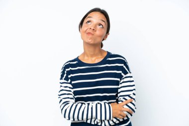 Young hispanic woman isolated on white background and looking up