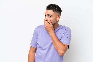 Beyaz arka planda izole edilmiş genç Arap yakışıklı adam yan tarafa bakarken sürpriz jest yapıyor.