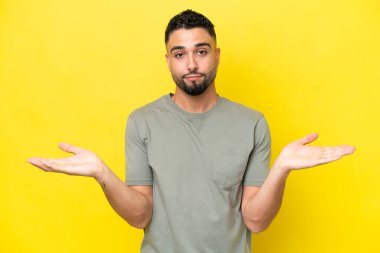 Sarı arka planda yaşayan yakışıklı Arap genç adamın şüpheleri var.