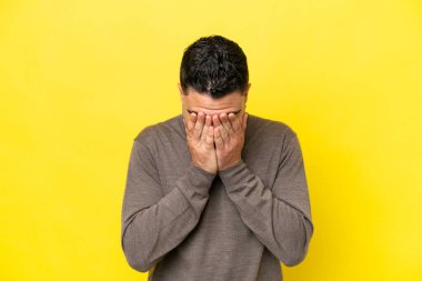 Genç Arap yakışıklı adam sarı arka planda izole edilmiş, yorgun ve hasta bir ifadeyle.