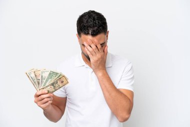 Young Arab man taking a lot of money isolated on white background with tired and sick expression