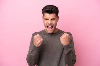 Pembe arka planda izole edilmiş genç beyaz adam kötü bir durum yüzünden hayal kırıklığına uğradı.