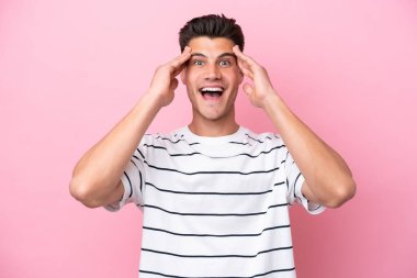 Young caucasian man isolated on pink background with surprise expression