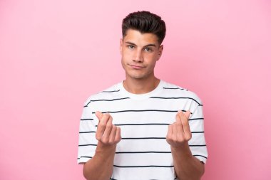 Pembe arka planda izole genç beyaz adam para hareketi yapıyor ama mahvoldu.