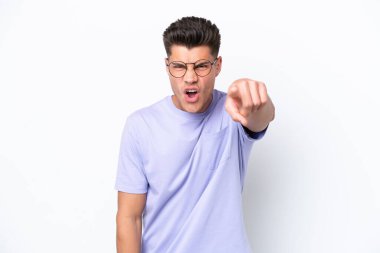 Beyaz arka planda izole edilmiş genç beyaz adam hayal kırıklığına uğramış ve ön tarafı işaret ediyor.