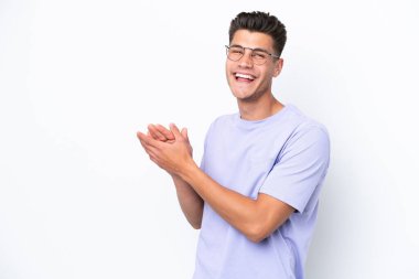 Beyaz arka planda izole edilmiş genç beyaz adam alkışlıyor.