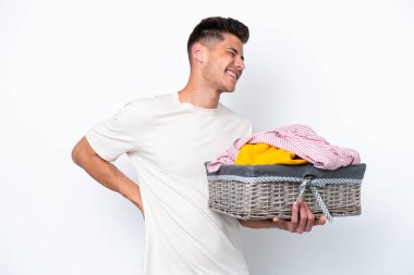 Young caucasian man holding laundry basket isolated on white background suffering from backache for having made an effort
