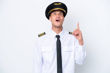 Airplane caucasian pilot isolated on white background pointing up and surprised