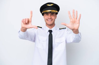 Beyaz arka planda izole edilmiş Kafkasyalı uçak pilotu yediyi parmaklarıyla sayıyor