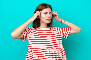 Mavi arka planda izole edilmiş genç bir İngiliz kadının şüpheleri ve düşünceleri var.