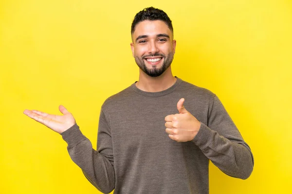 Young Arab Handsome Man Isolated Yellow Background Holding Copyspace Imaginary — 스톡 사진