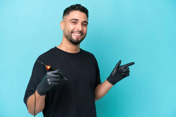 Tattooist Arab Man Isolated Blue Background Pointing Finger Side — 스톡 사진