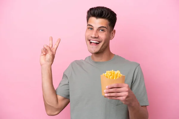 Jonge Blanke Man Met Gebakken Chips Geïsoleerd Roze Achtergrond Glimlachen — Stockfoto