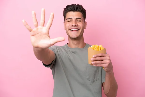 Young Caucasian Man Holding Fried Chips Isolated Pink Background Counting — Stockfoto