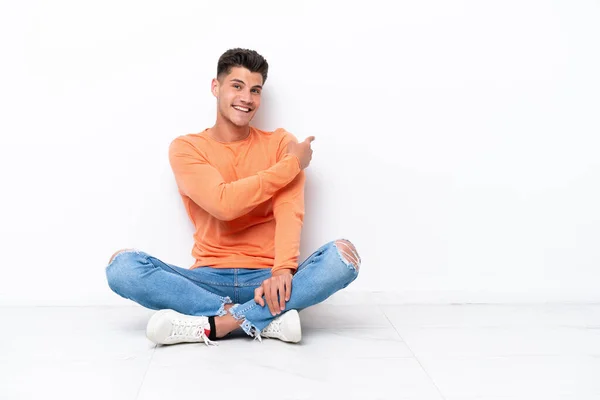 Jongeman Zit Vloer Geïsoleerd Witte Achtergrond Wijzend Terug — Stockfoto