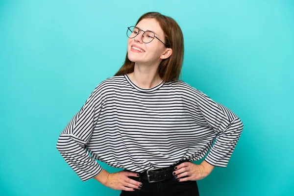 Young English Woman Isolated Blue Background Posing Arms Hip Smiling — Stockfoto