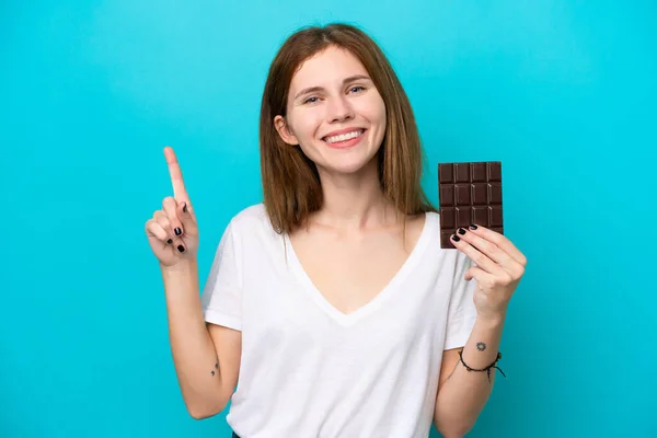 Young English Woman Chocolat Isolated Blue Background Showing Lifting Finger — Stock fotografie