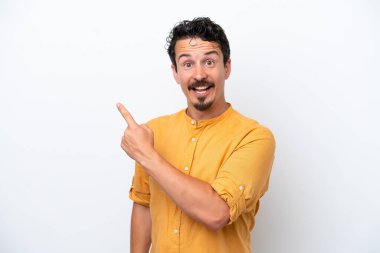 Young man with moustache isolated on white background surprised and pointing side