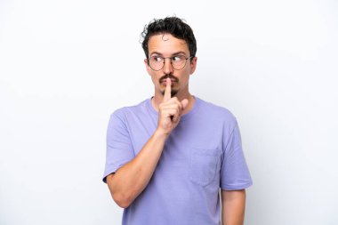 Young man with moustache isolated on white background showing a sign of silence gesture putting finger in mouth