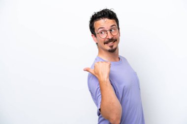 Young man with moustache isolated on white background pointing to the side to present a product