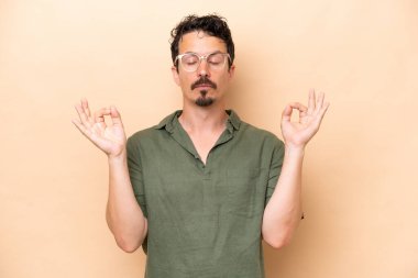 Zen pozunda bej arka planda izole edilmiş beyaz bir genç.