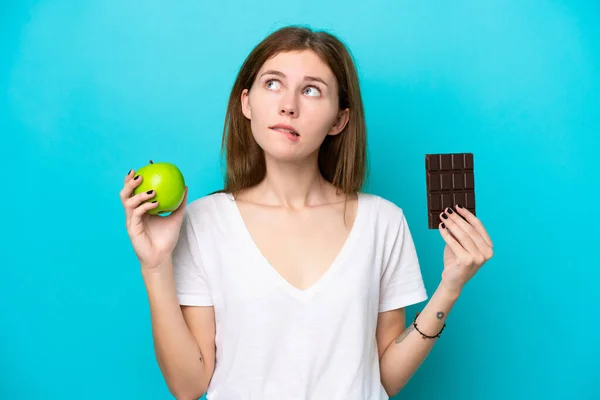 Mladá Anglická Žena Izolovaná Modrém Pozadí Pochybnostmi Při Užívání Čokoládové — Stock fotografie