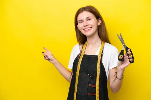 Young Seamstress English Woman Isolated Yellow Background Pointing Finger Side — Stockfoto