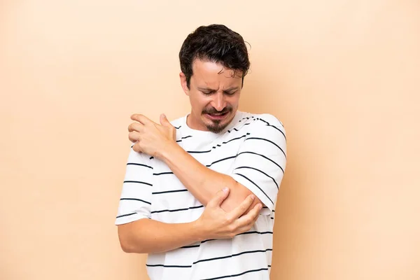 Young Caucasian Man Isolated Beige Background Pain Elbow — Stok fotoğraf