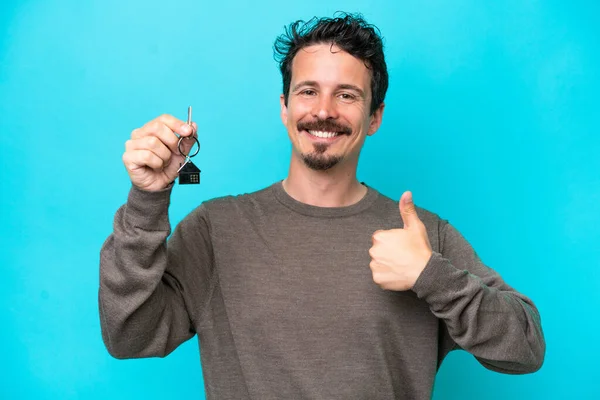 Young Caucasian Man Holding Home Keys Isolated Blue Background Thumbs — Stockfoto