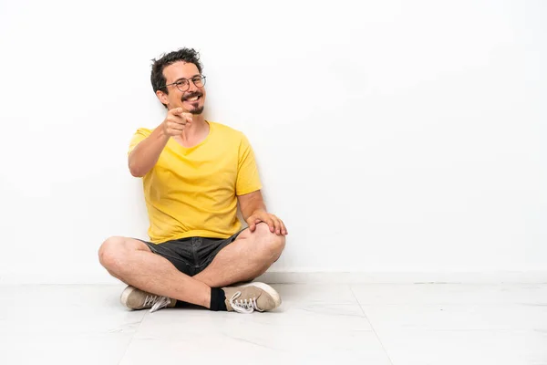 Young Caucasian Man Sitting Floor Isolated White Background Points Finger — Foto de Stock