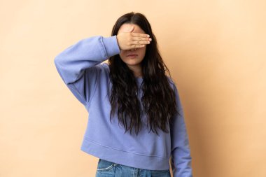 İzole edilmiş arka planda genç beyaz bir kadın elleriyle gözlerini kapatıyor. Bir şey görmek istemiyorum.