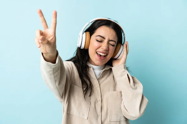 Νεαρή Καυκάσια Γυναίκα Απομονωμένη Μπλε Φόντο Ακούγοντας Μουσική Και Τραγουδώντας — Φωτογραφία Αρχείου