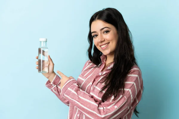 Jovem Com Uma Água Isolada Fundo Azul Apontando — Fotografia de Stock