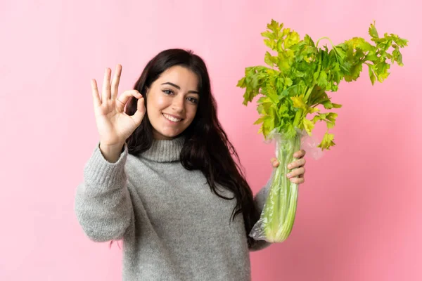 Young Caucasian Woman Holding Celery Isolated Blue Background Showing Sign — Foto de Stock
