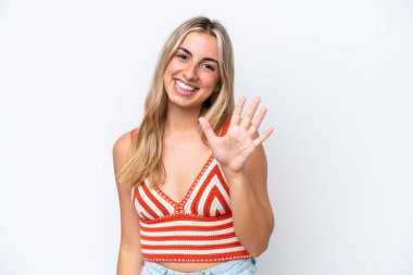 Beyaz arka planda izole edilmiş beyaz tenli genç kadın parmaklarıyla beşi sayıyor.