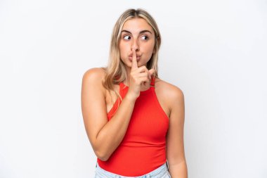 Beyaz arka planda izole edilmiş beyaz bir kadın sessiz bir jest işareti gösteriyor. Parmağını ağzına sokuyor.