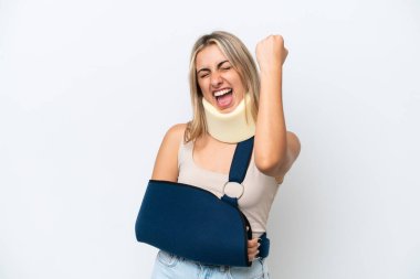 Woman with broken arm and wearing a sling isolated on white background celebrating a victory
