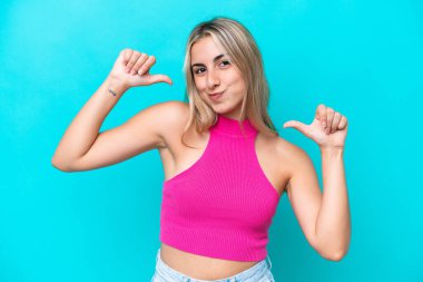 Mavi arka planda soyutlanmış, gururlu ve kendini beğenmiş beyaz bir kadın.