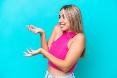 Mavi arka planda mahsur kalmış beyaz bir kadın. Sürpriz bir ifadeyle yan tarafa bakarken.