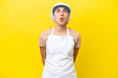 Fishwife woman over isolated background looking up and with surprised expression