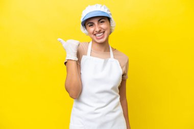 Balıkçı kadın izole edilmiş arka planda bir ürün sunmak için kenarı işaret ediyor.