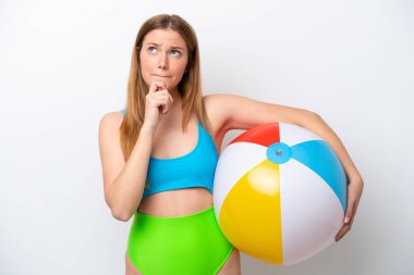 Tatillerde elinde plaj topu tutan genç bir kadın beyaz arka planda izole edilmiş şüpheleri ve düşünceleri var.